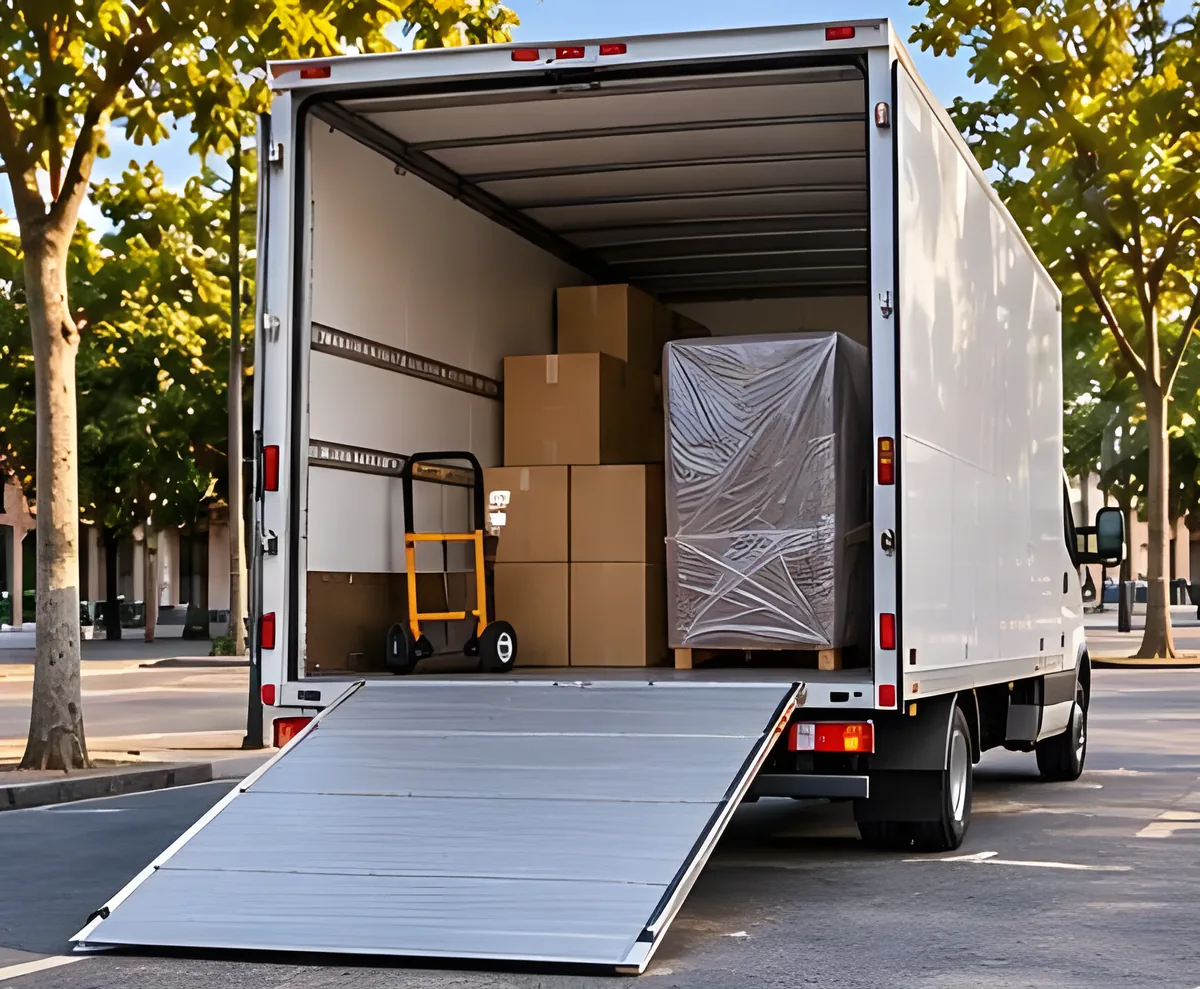Camión abierto con cajas y un mueble protegido, y una rampa